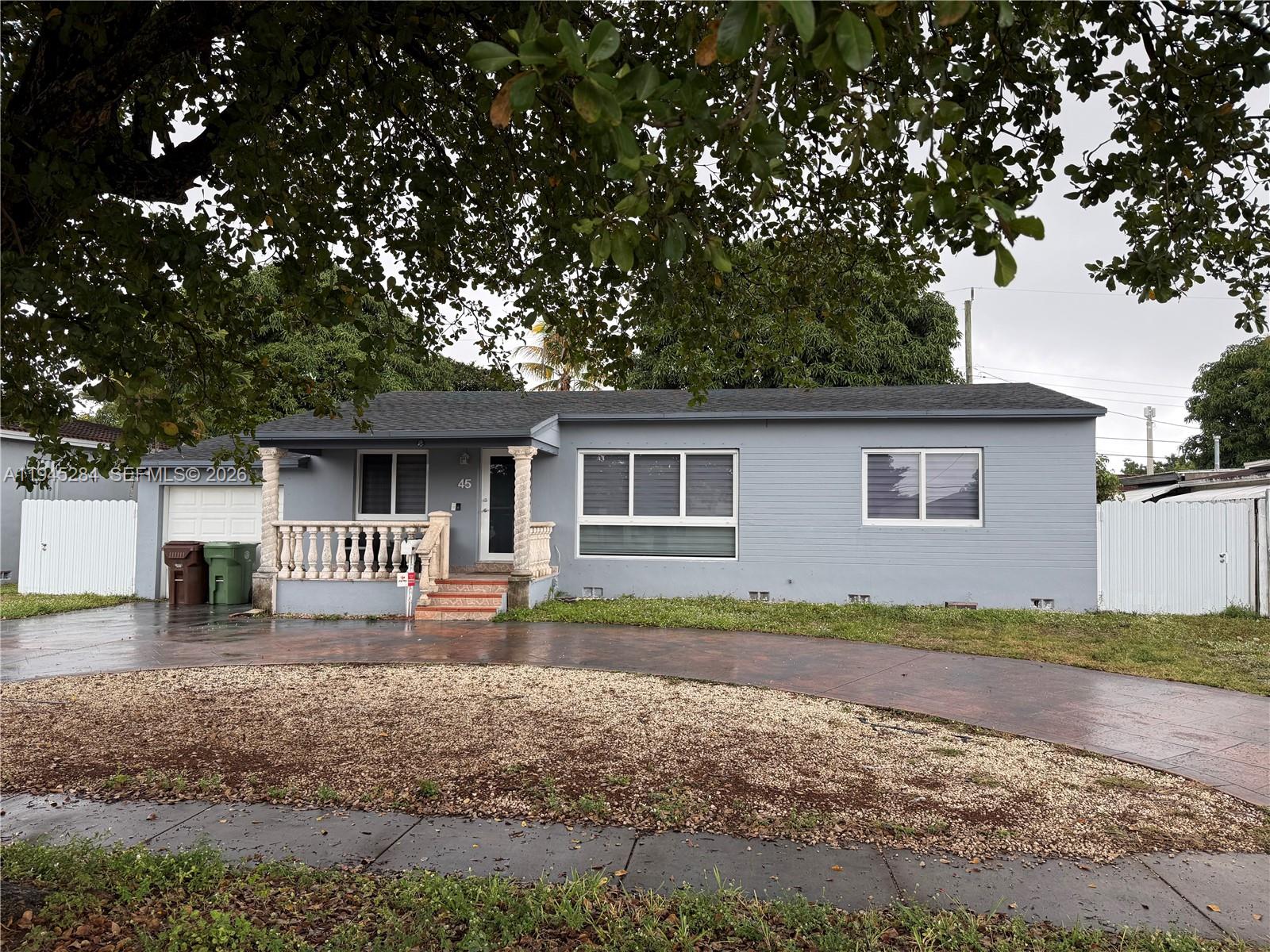 45 West 60th Street Hialeah, FL 33012 - Photo 2 of 11 a front view of house with yard and trees in the background