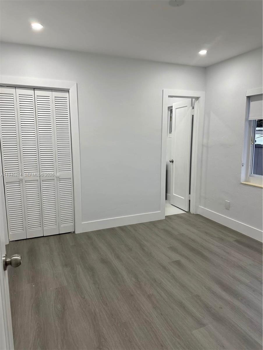 45 West 60th Street Hialeah, FL 33012 - Photo 6 of 11 an empty room with wooden floor and windows