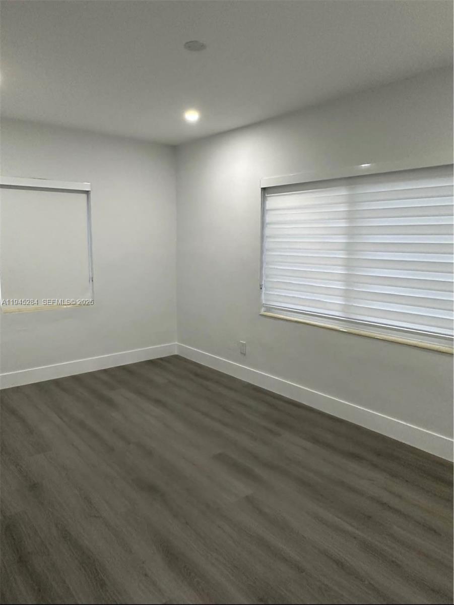 45 West 60th Street Hialeah, FL 33012 - Photo 9 of 11 an empty room with wooden floor and windows