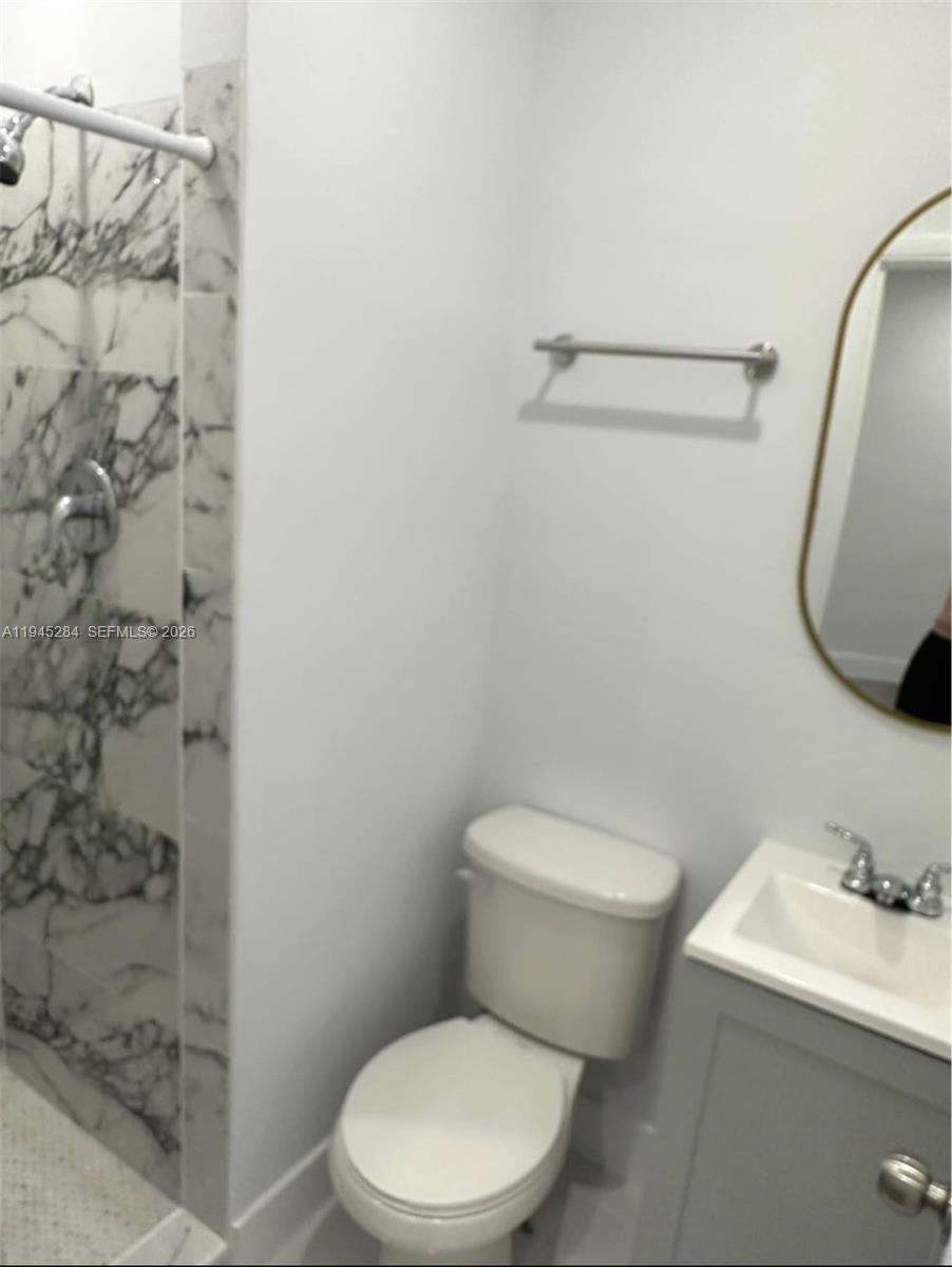 45 West 60th Street Hialeah, FL 33012 - Photo 10 of 11 a white toilet sitting next to a bathroom sink and a shower