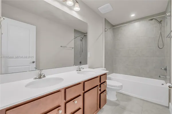 a bathroom with a sink double vanity granite tub toilet and shower