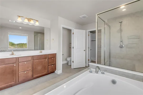 a spacious bathroom with a double vanity sink mirror and shower