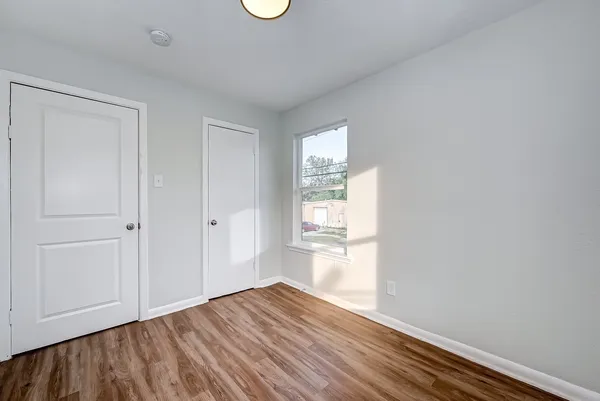 a view of an empty room with wooden floor