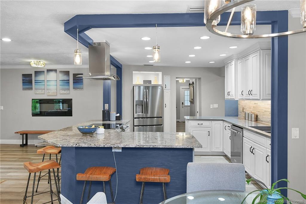 6 Copaire Road Sewall's Point, FL 34996 - Photo 32 of 76 a large kitchen with granite countertop a sink and a refrigerator