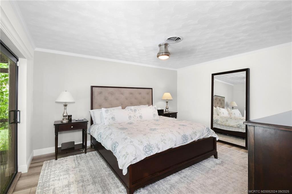 6 Copaire Road Sewall's Point, FL 34996 - Photo 55 of 76 a bedroom with a bed and wooden floor