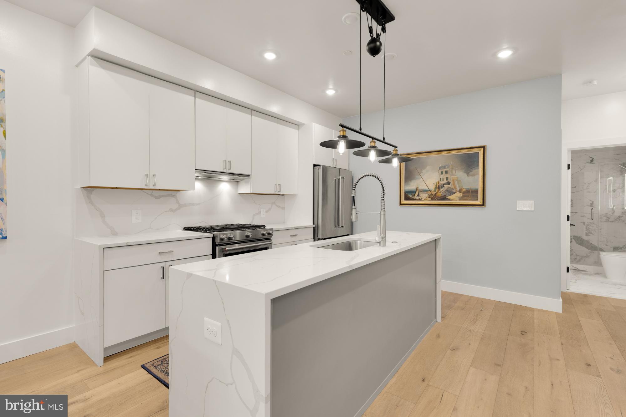 81 U Street Northwest, Unit A Washington, DC 20001 - Photo 12 of 46 a kitchen with kitchen island a white cabinets and refrigerator