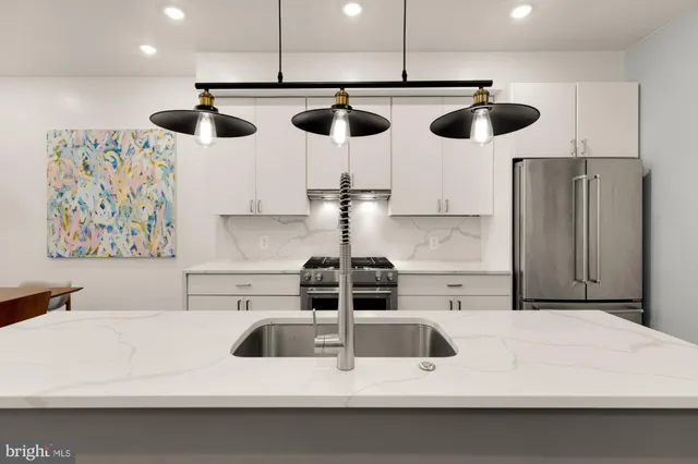 a kitchen with a refrigerator and chairs