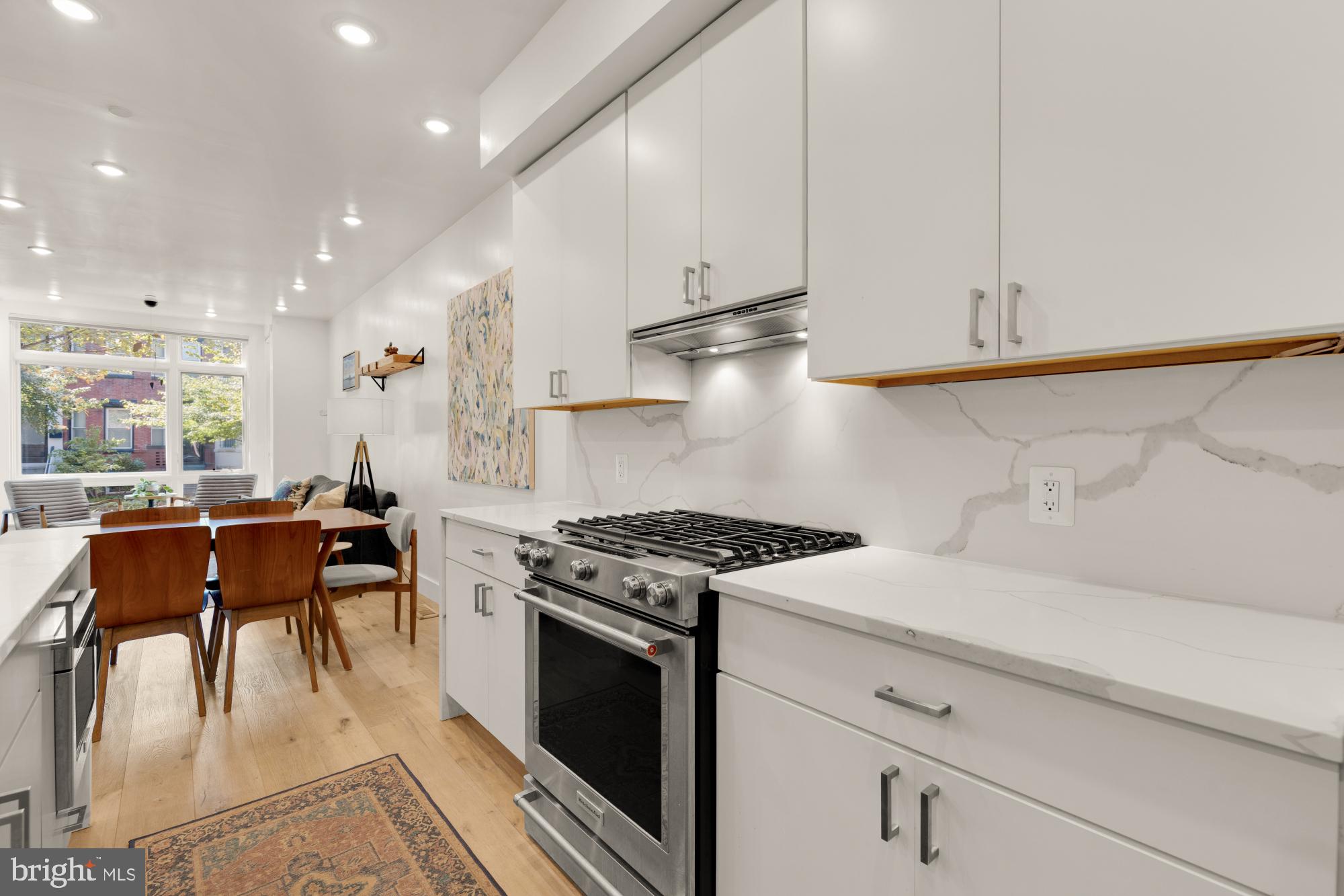81 U Street Northwest, Unit A Washington, DC 20001 - Photo 19 of 46 a kitchen with stainless steel appliances kitchen island granite countertop a stove a sink a refrigerator and white cabinets