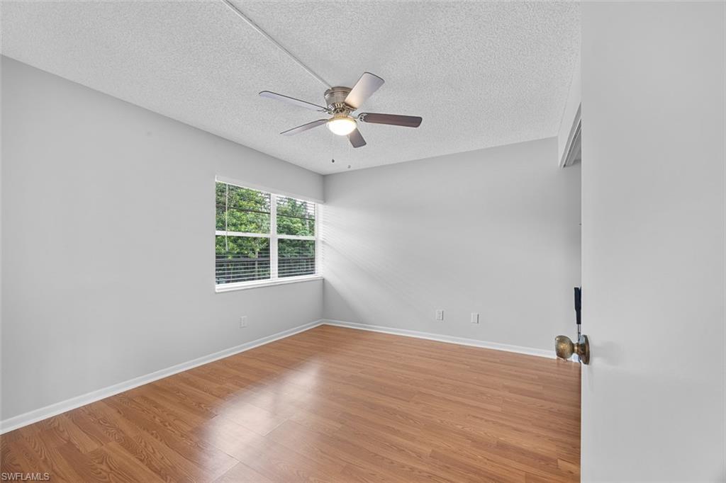 1083 Forest Lakes Drive, Unit 207 Naples, FL 34105 - Photo 12 of 21 wooden floor in an empty room with a window