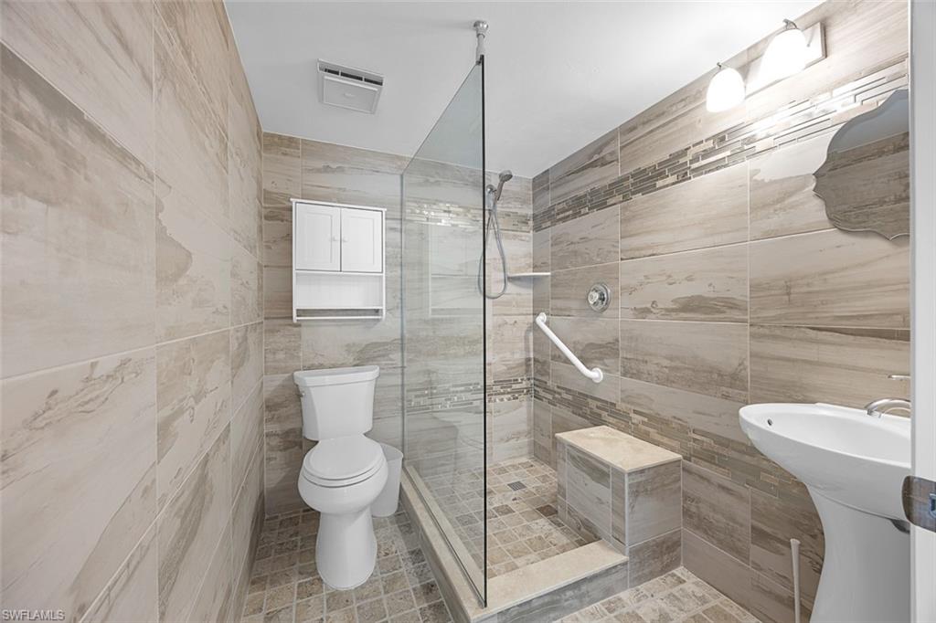 1083 Forest Lakes Drive, Unit 207 Naples, FL 34105 - Photo 15 of 21 a bathroom with a toilet and a shower
