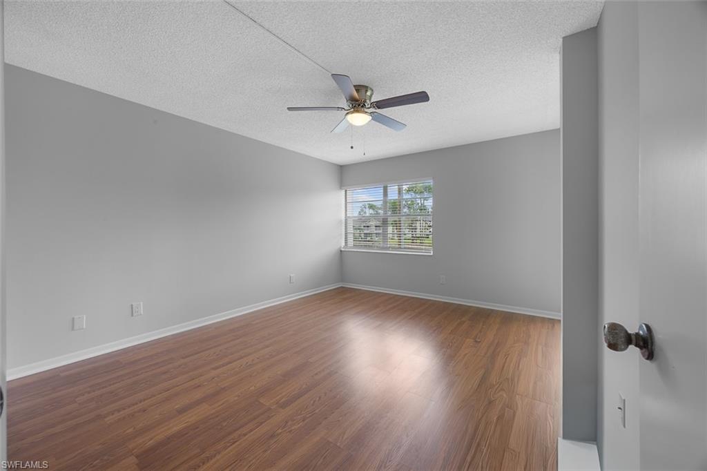 1083 Forest Lakes Drive, Unit 207 Naples, FL 34105 - Photo 16 of 21 wooden floor in an empty room with a window