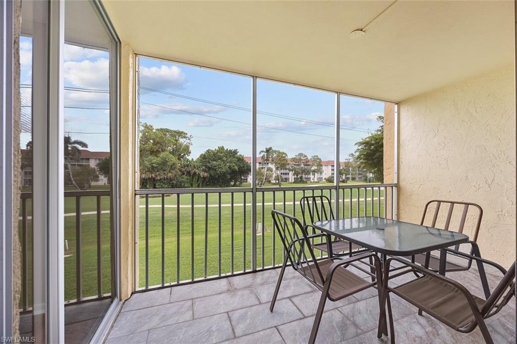 1083 Forest Lakes Drive, Unit 207 Naples, FL 34105 - Photo 19 of 21 a view of a balcony with furniture and a floor to ceiling window