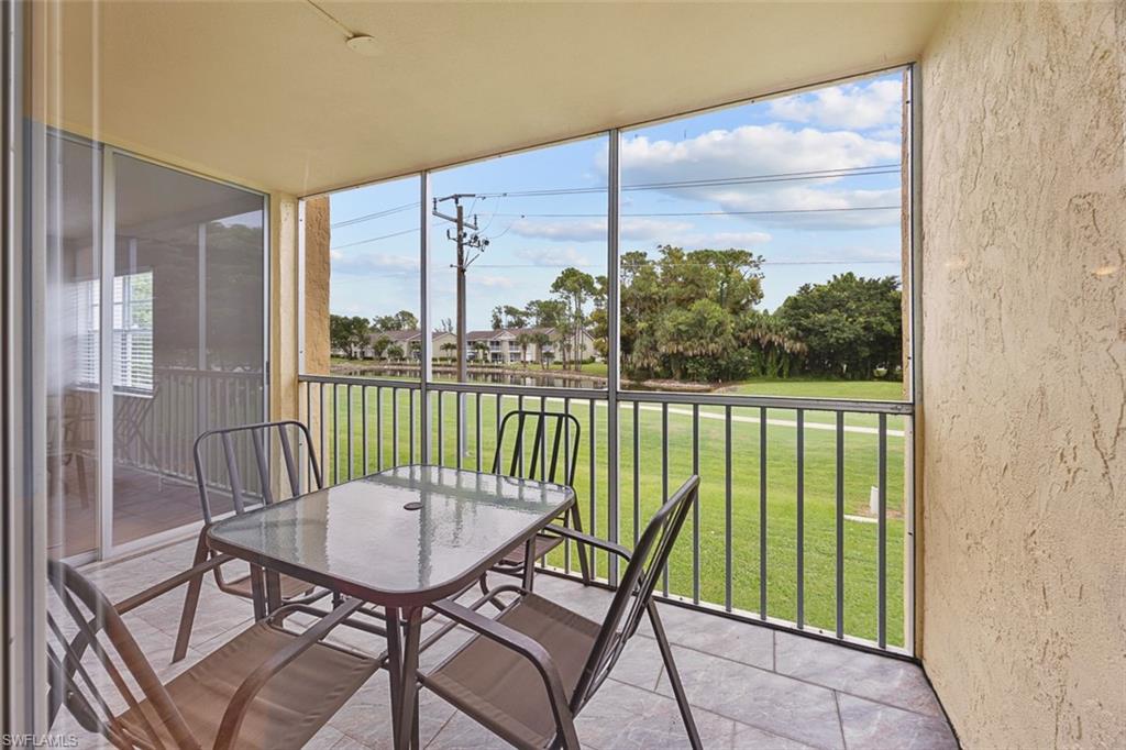 1083 Forest Lakes Drive, Unit 207 Naples, FL 34105 - Photo 20 of 21 a view of a balcony with a table and chairs
