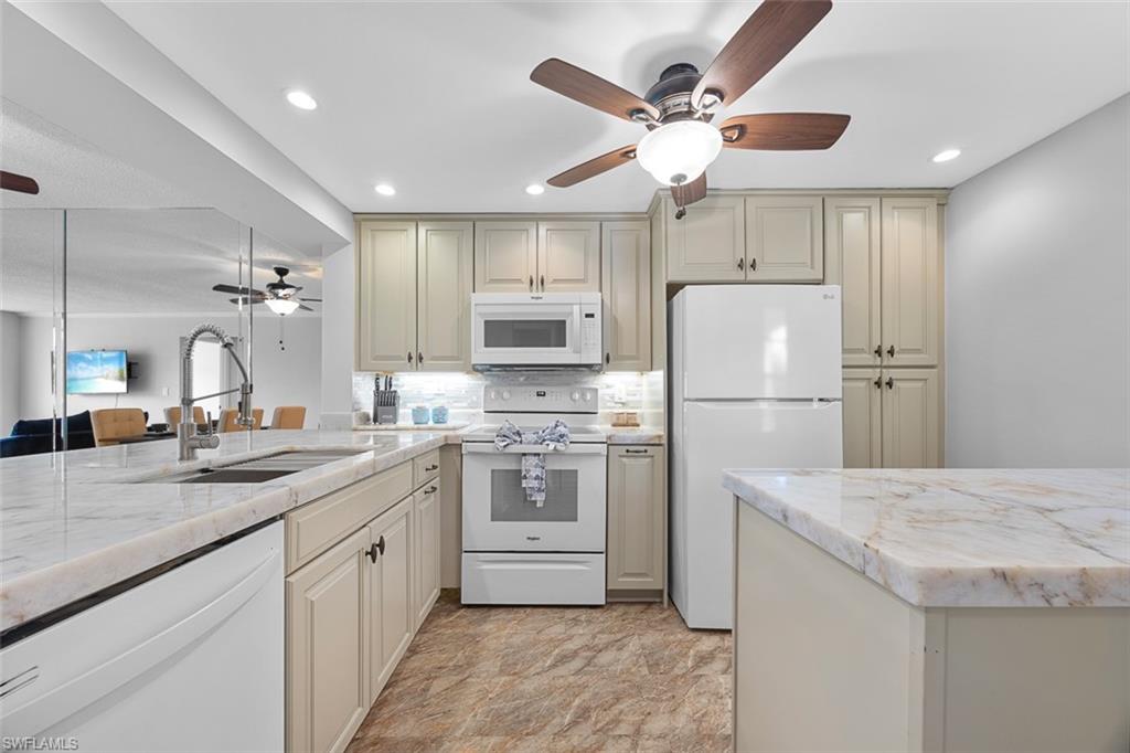 1083 Forest Lakes Drive, Unit 207 Naples, FL 34105 - Photo 5 of 21 a kitchen with kitchen island a sink stainless steel appliances and refrigerator