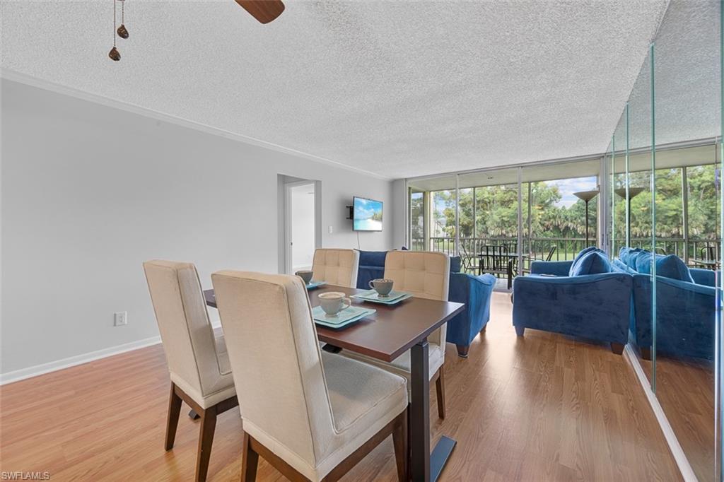 1083 Forest Lakes Drive, Unit 207 Naples, FL 34105 - Photo 7 of 21 a view of a dining room with furniture wooden floor and a rug