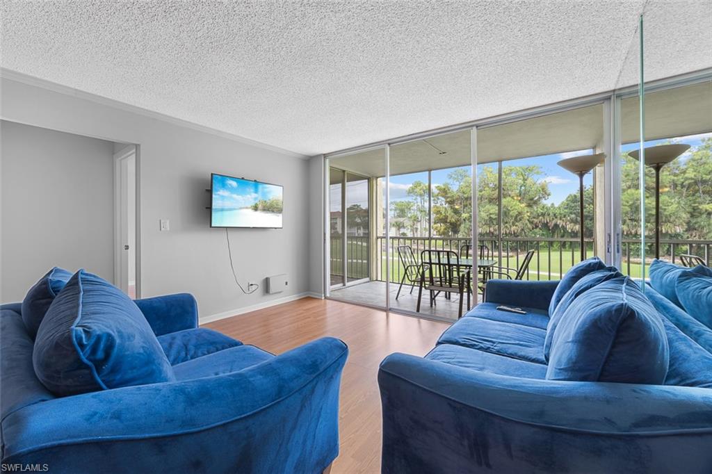 1083 Forest Lakes Drive, Unit 207 Naples, FL 34105 - Photo 8 of 21 a living room with furniture and a large window
