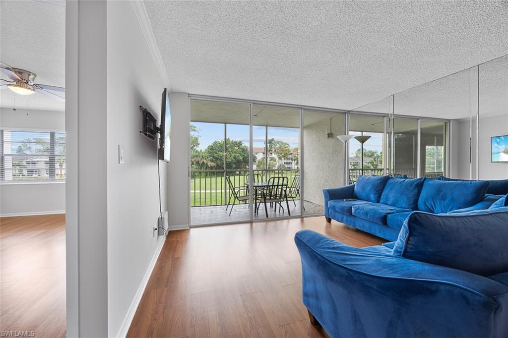 1083 Forest Lakes Drive, Unit 207 Naples, FL 34105 - Photo 9 of 21 a living room with furniture and a flat screen tv