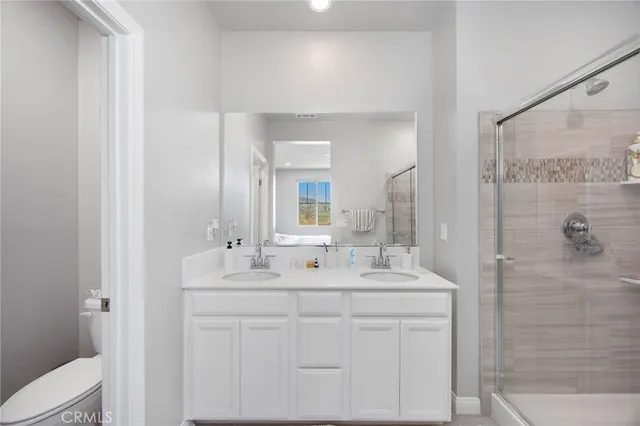 a bathroom with a double vanity sink mirror and shower