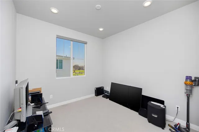 a bedroom with a bed and a computer on the desk