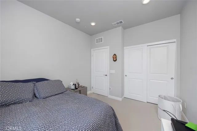 a spacious bedroom with a bed and a rug