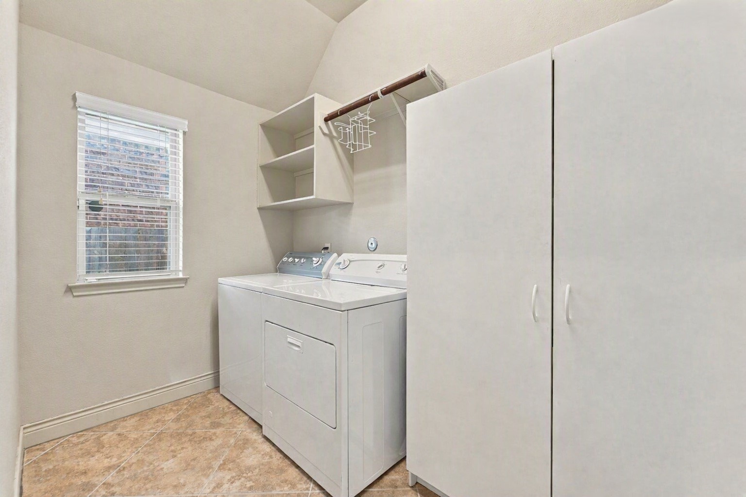 9818 Reston Ranch Court Cypress, TX 77433 - Photo 31 of 38 Ready for everyday laundry needs, this utility room includes a hanging rod, open shelves, and ample cabinet storage. Edited using AI tools.
