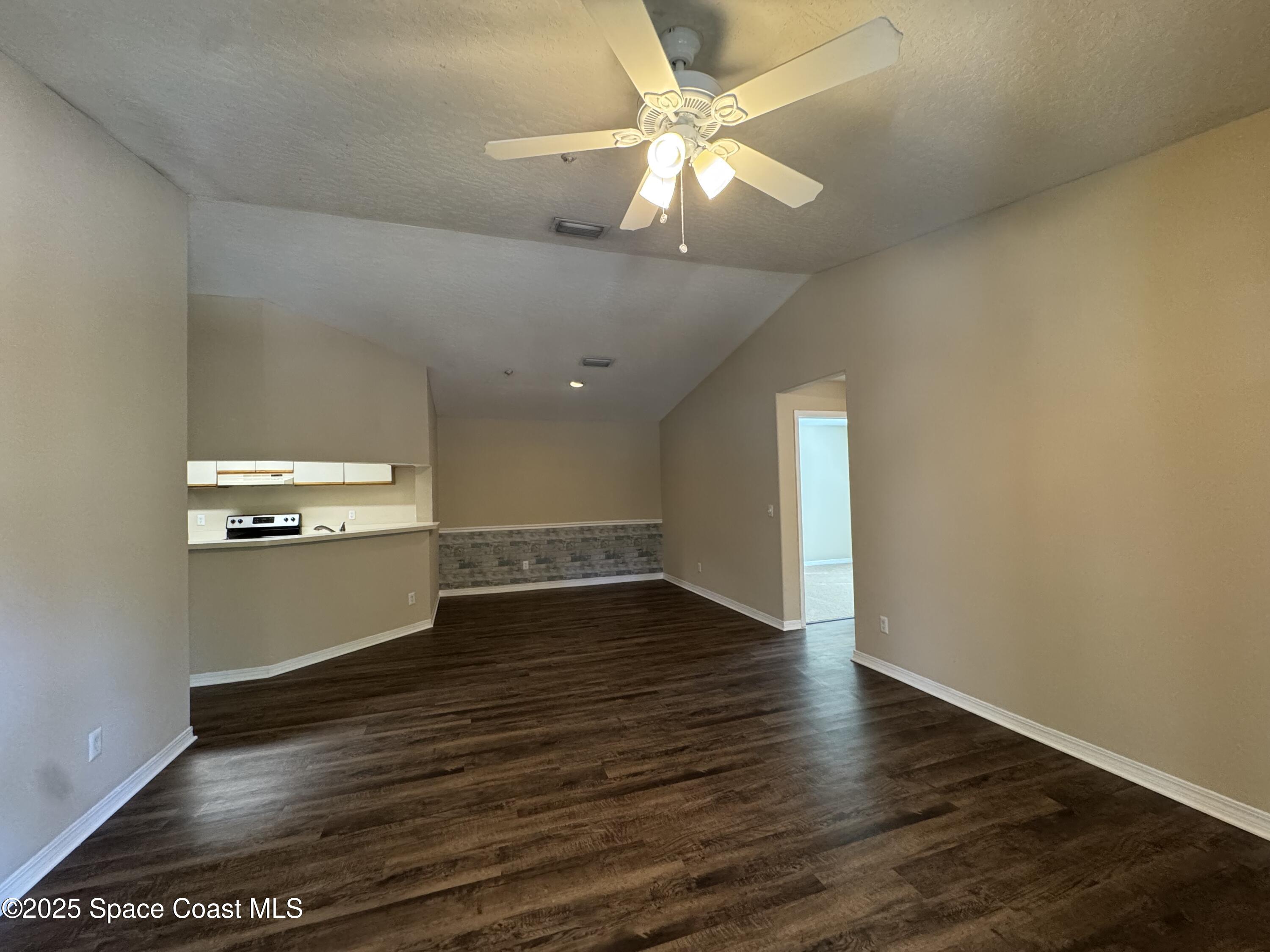 7667 North Wickham Road, Unit 1215 Melbourne, FL 32940 - Photo 4 of 31 an empty room with wooden floor and windows