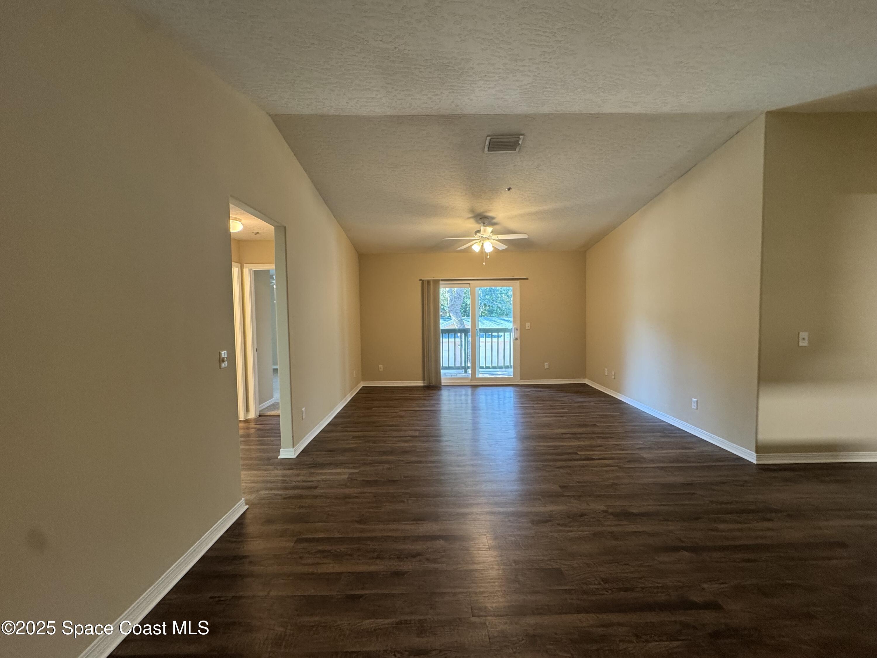 7667 North Wickham Road, Unit 1215 Melbourne, FL 32940 - Photo 5 of 31 a view of an empty room with wooden floor