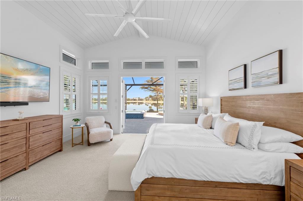 14785 Dockside Lane Naples, FL 34114 - Photo 13 of 50 Carpeted bedroom with access to outside, multiple windows, ceiling fan, a sunroom, and lofted ceiling with beams New MOUNTED TV & SONOS SOUND BAR (November 2018), New CEILING FAN (November 2018)