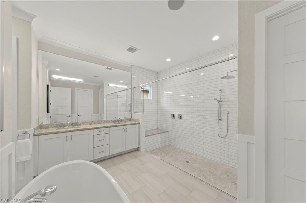14785 Dockside Lane Naples, FL 34114 - Photo 16 of 50 Bathroom with double vanity, a tile shower, a soaking tub, crown molding, and recessed lighting New CUSTOM MIRROR & SCONCES (February 2020), New WALLPAPER (June 2020), New PRIMARY BATH CEILING PAINT (July 2023)