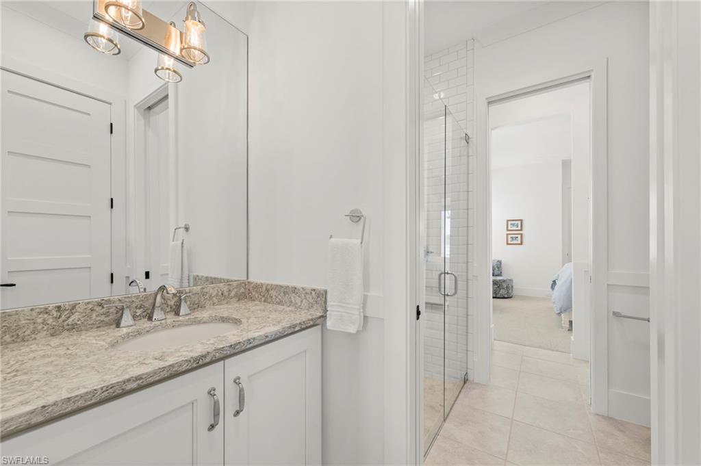 14785 Dockside Lane Naples, FL 34114 - Photo 22 of 50 Ensuite bathroom featuring vanity, a shower stall, and light tile patterned floors