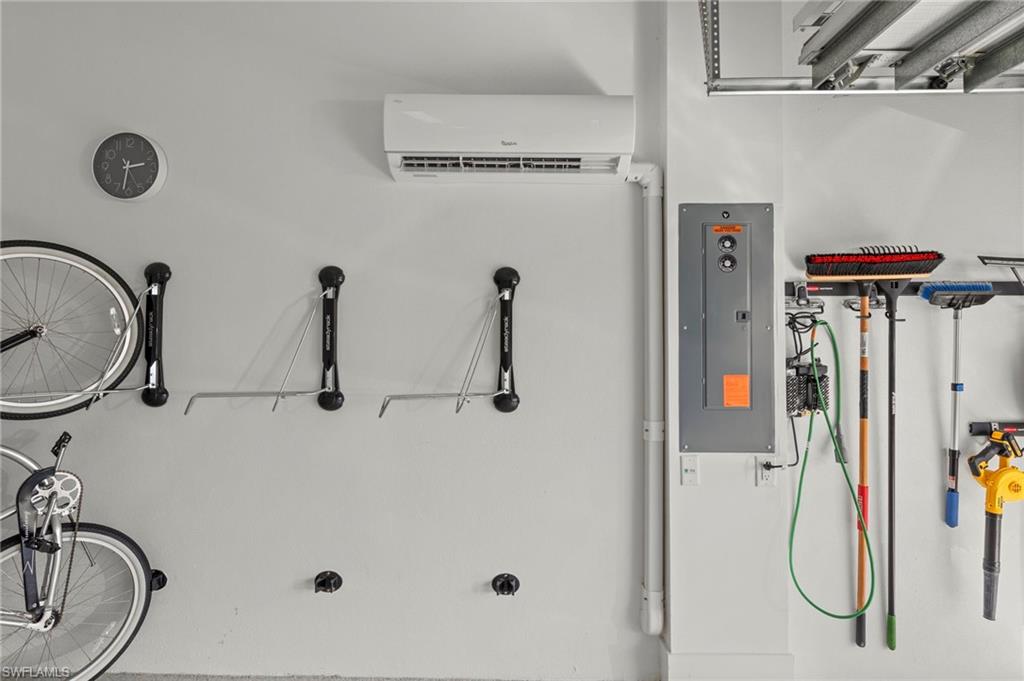 14785 Dockside Lane Naples, FL 34114 - Photo 30 of 50 Utility room featuring electric panel and a wall mounted mini split New CUSTOM CALIFORNIA CLOSET ORGANIZERS (February 2020), New MINI-SPLIT AC (May 2020), New electrical panel SURGER PROTECTOR (October 2022), New GARAGE INTERIOR PAINT (July 2023)