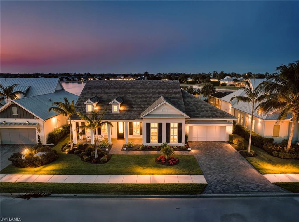 14785 Dockside Lane Naples, FL 34114 - Photo 3 of 50 View of front of house featuring a porch, decorative driveway, an attached garage, and a front lawn New VITEX SMART HOME AUTOMATION SYSTEM (November 2019), New LANDSCAPE LIGHTING (February 2019)