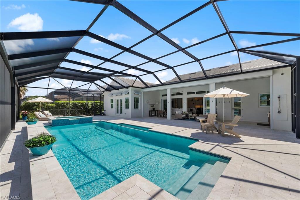 14785 Dockside Lane Naples, FL 34114 - Photo 39 of 50 Integrated pool / hot tub featuring a sunroom, a patio, and a lanai