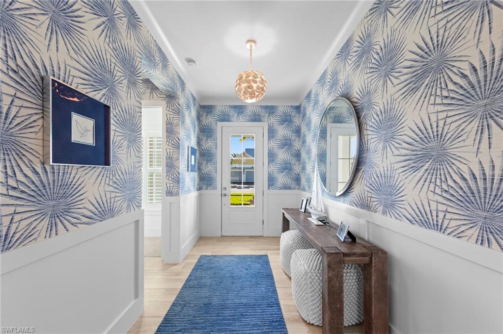 14785 Dockside Lane Naples, FL 34114 - Photo 5 of 50 Entryway with wainscoting, wood finished floors, and wallpapered walls New CHANDELIER (November 2018), New WALLPAPER (June 2020)
