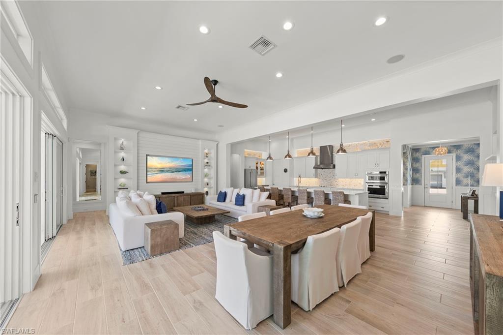 14785 Dockside Lane Naples, FL 34114 - Photo 6 of 50 Living room featuring light wood-style floors, recessed lighting, and a ceiling fan New MOUNTED TV & SONOS SOUND BAR (November 2018), New KITCHEN PENDANTS (November 2018), New SHIPLAP BUILT-IN & WALLS (May 2020), New KITCHEN INTERIOR PAINT (July 2023)New CEILING FAN (October 2024)