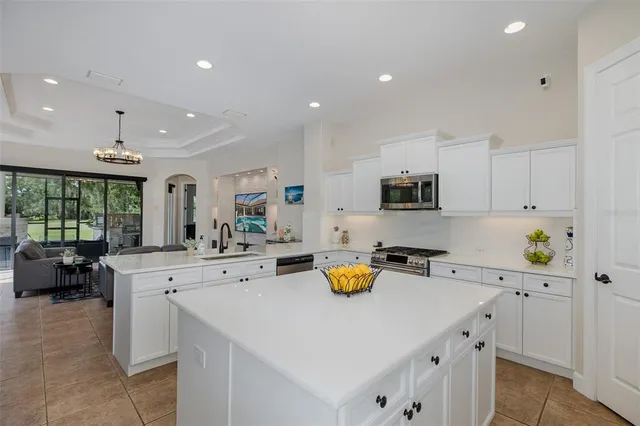 a kitchen with kitchen island white cabinets and white appliances