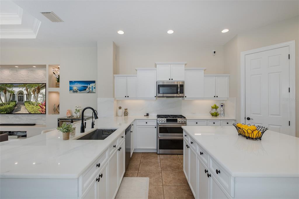1429 El Pardo Drive Trinity, FL 34655 - Photo 6 of 100 a kitchen with kitchen island white cabinets and white appliances