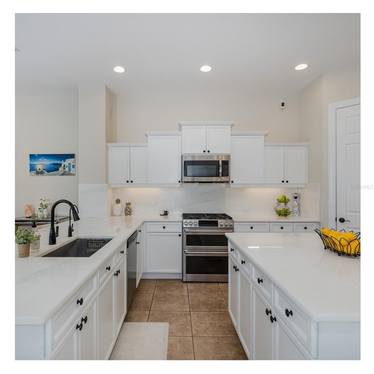 1429 El Pardo Drive Trinity, FL 34655 - Photo 9 of 100 a kitchen with stainless steel appliances a sink stove and cabinets