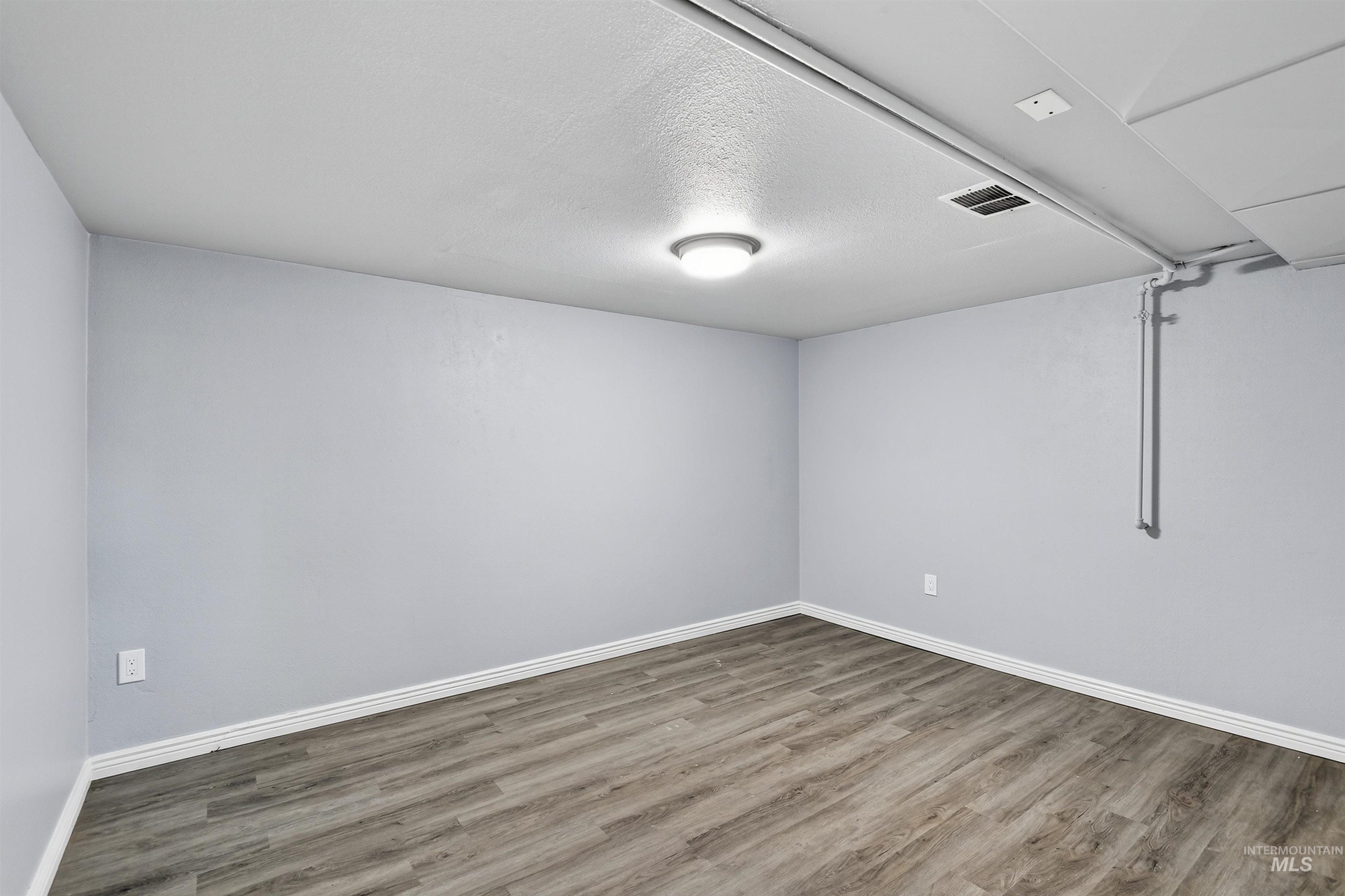 2118 West Targee Street Boise, ID 83705 - Photo 13 of 25 Unfurnished room with wood finished floors and a textured ceiling