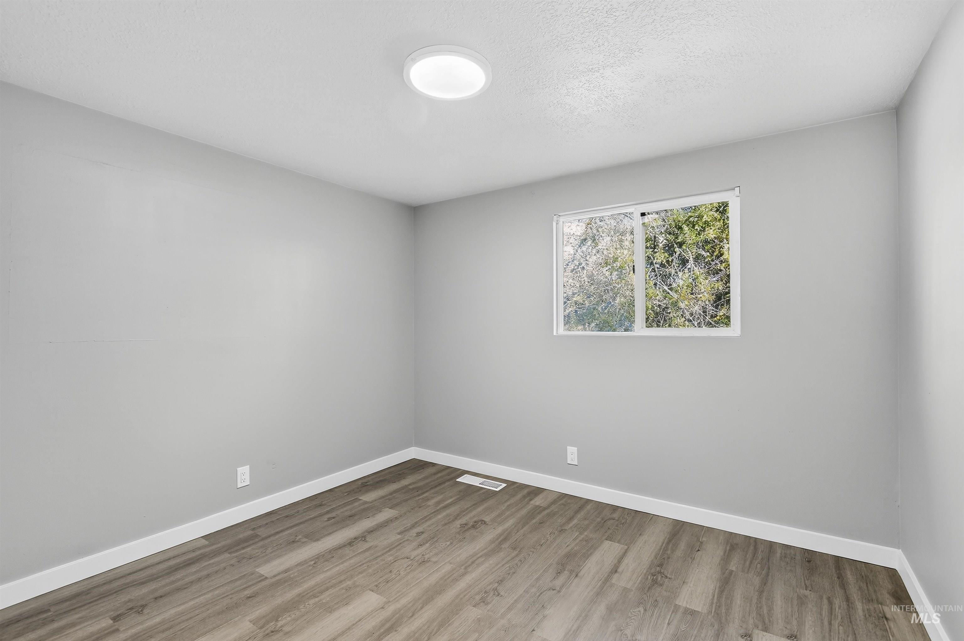 2118 West Targee Street Boise, ID 83705 - Photo 9 of 25 Unfurnished room with light wood-style flooring and a textured ceiling
