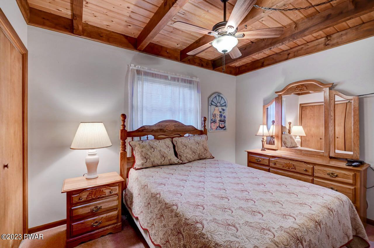 413 Northgate Road Lake Ariel, PA 18436 - Photo 26 of 59 a bedroom with a bed and a chandelier with a flat tv screen