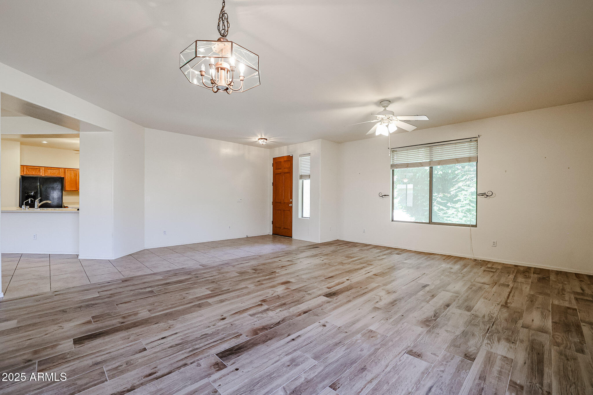 16617 North 40th Drive Phoenix, AZ 85053 - Photo 8 of 15 a view of an empty room with wooden floor and a window