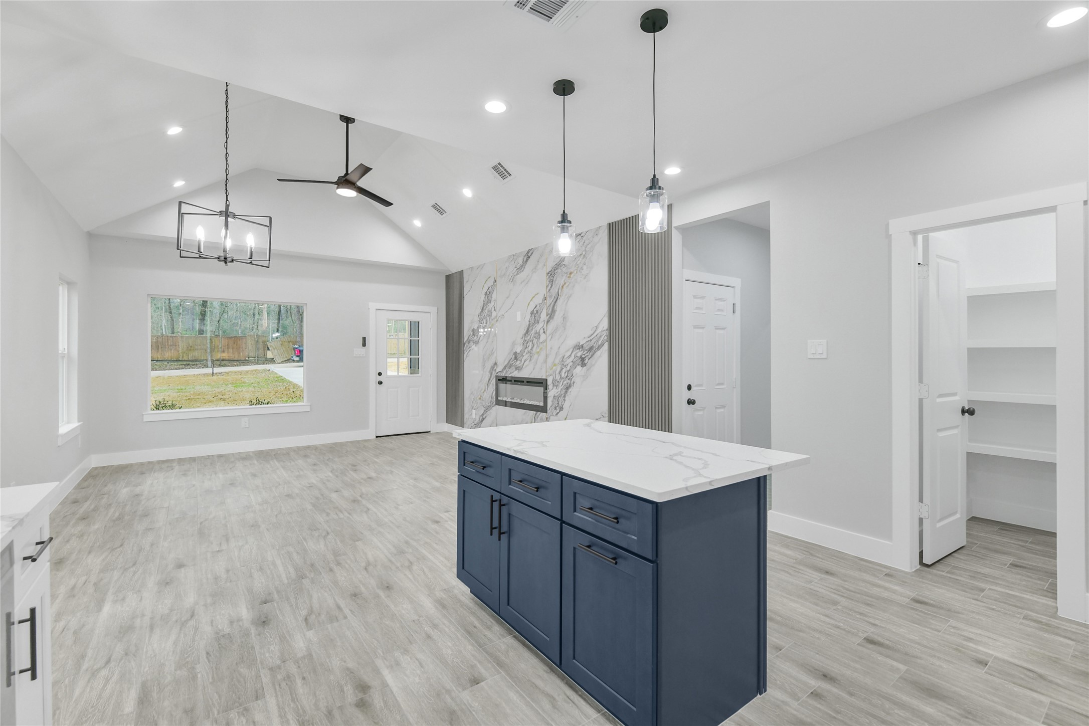 15117 Austin Road Willis, TX 77378 - Photo 12 of 35 a large room with stainless steel appliances kitchen island a chandelier and wooden floor
