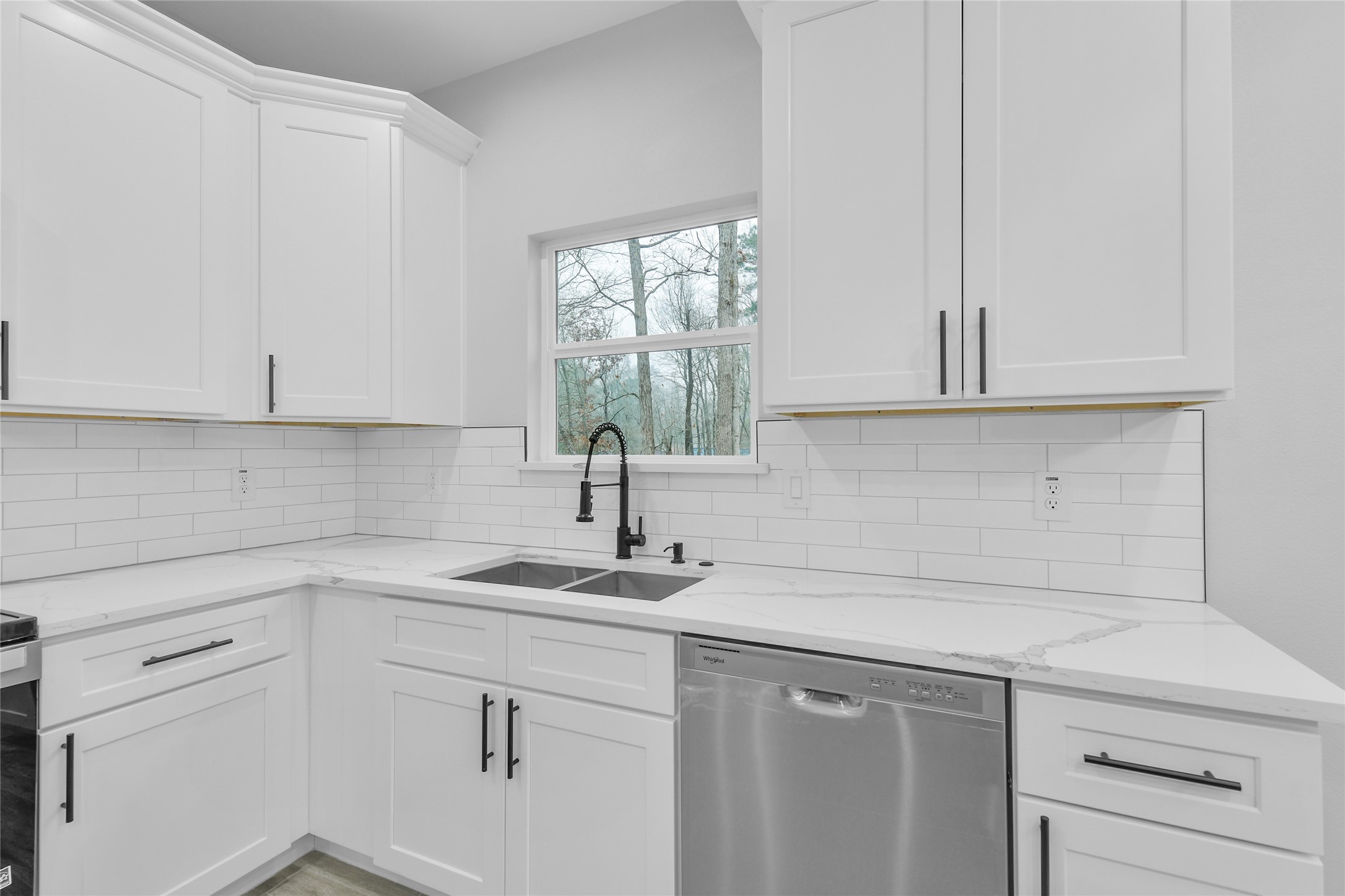 15117 Austin Road Willis, TX 77378 - Photo 14 of 35 a kitchen with white cabinets and a window