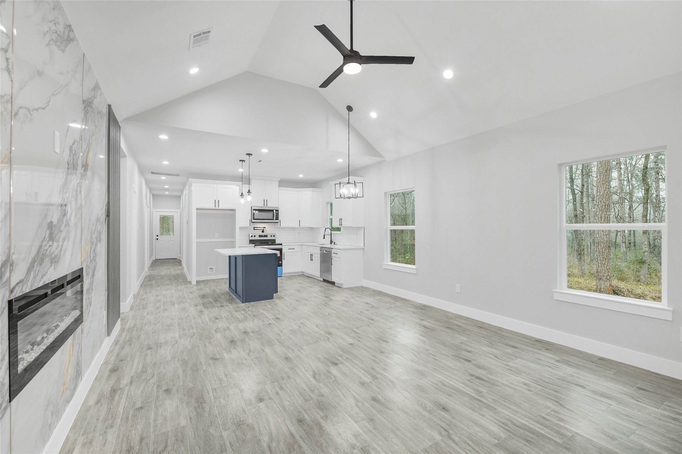 15117 Austin Road Willis, TX 77378 - Photo 5 of 35 a kitchen with stainless steel appliances kitchen island a large counter top and a wooden floors