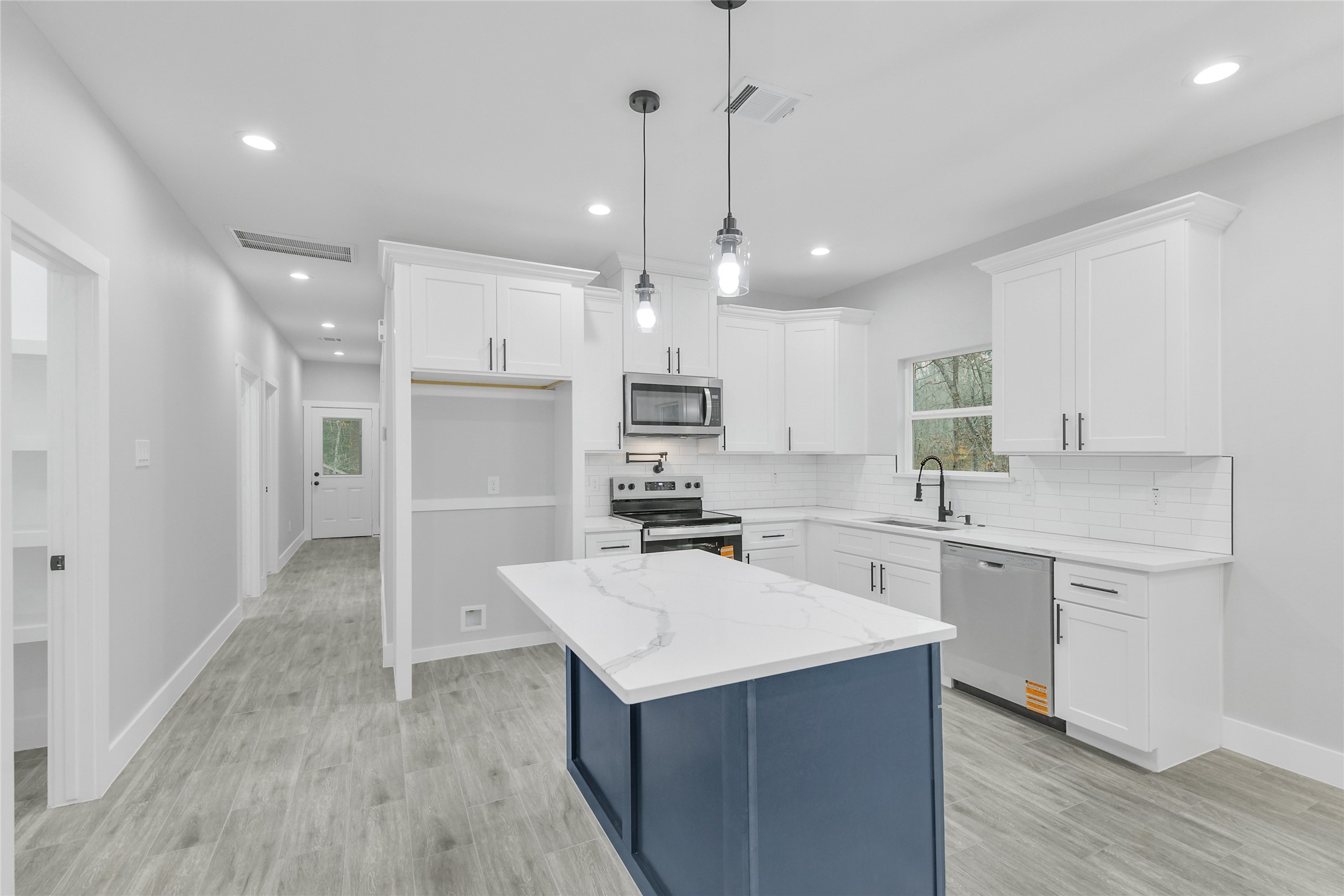 15117 Austin Road Willis, TX 77378 - Photo 9 of 35 a kitchen with a sink refrigerator and microwave