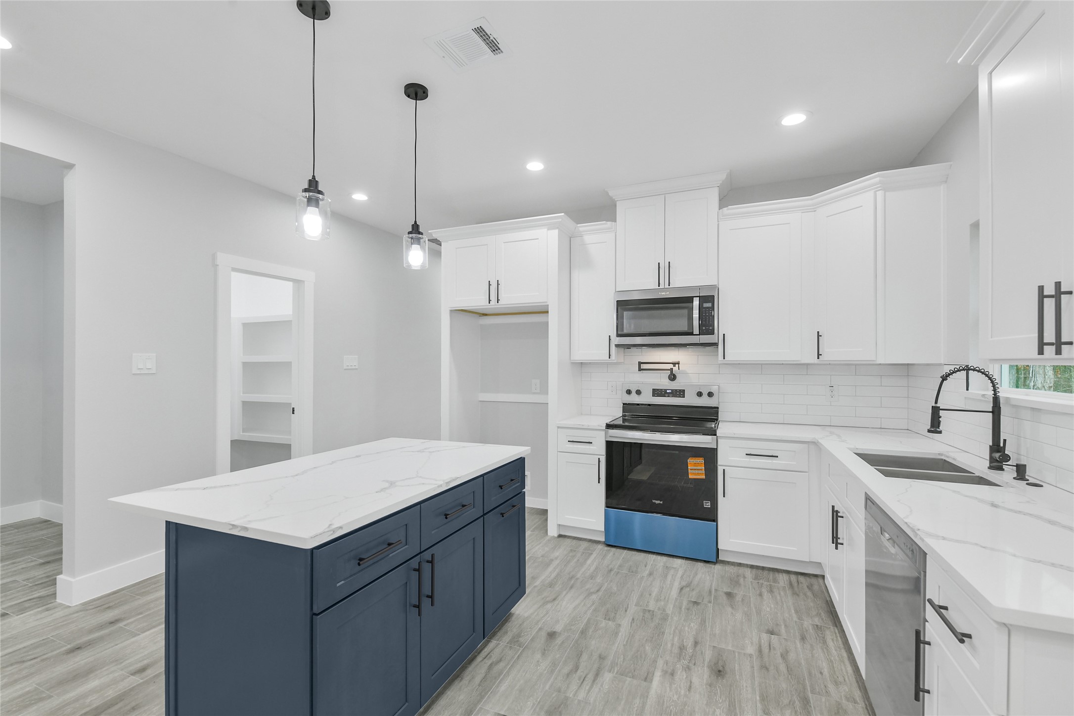 15117 Austin Road Willis, TX 77378 - Photo 10 of 35 a kitchen with kitchen island white cabinets appliances and sink