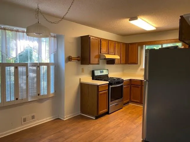 a kitchen with stainless steel appliances granite countertop a stove a refrigerator and a sink