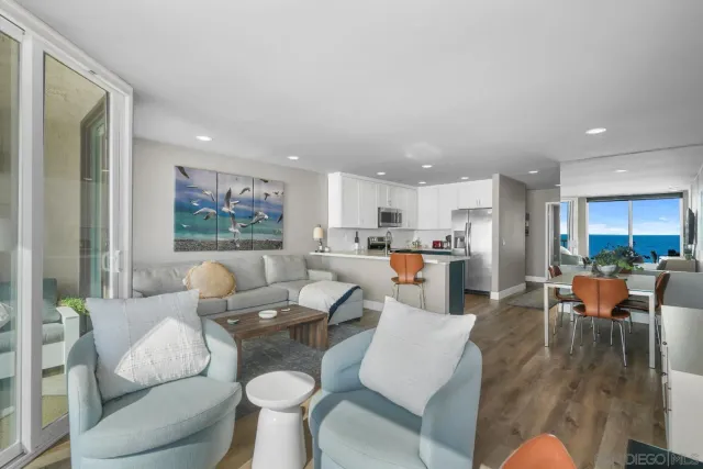 a living room with furniture kitchen view and a large window