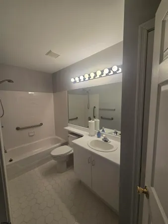 a bathroom with a double vanity sink a toilet and a mirror